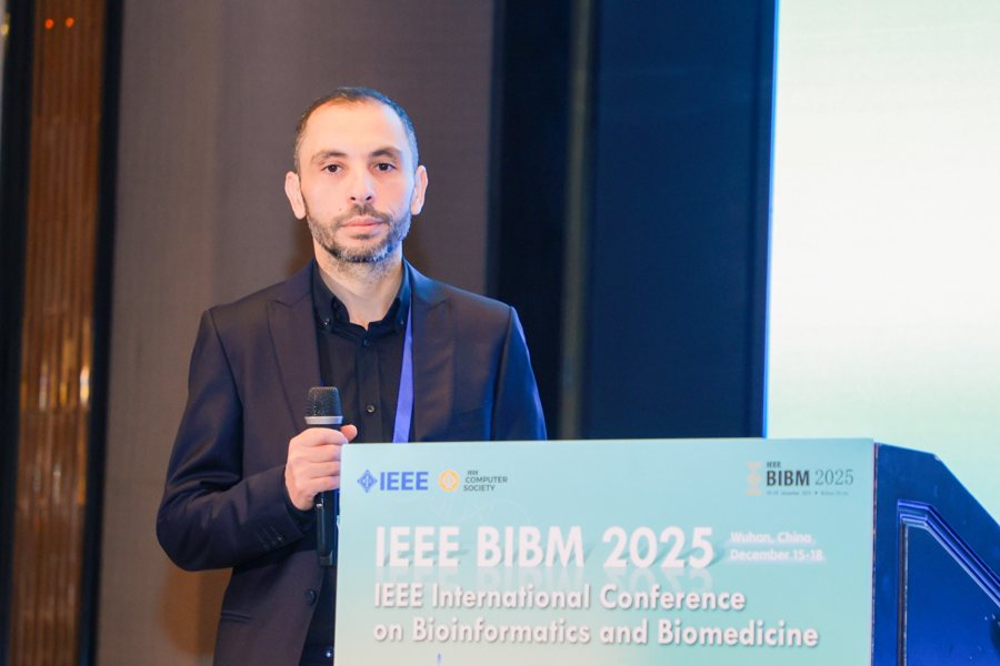 Dr Haithem Afli speaking at the IEEE BIBM 2025 conference podium.